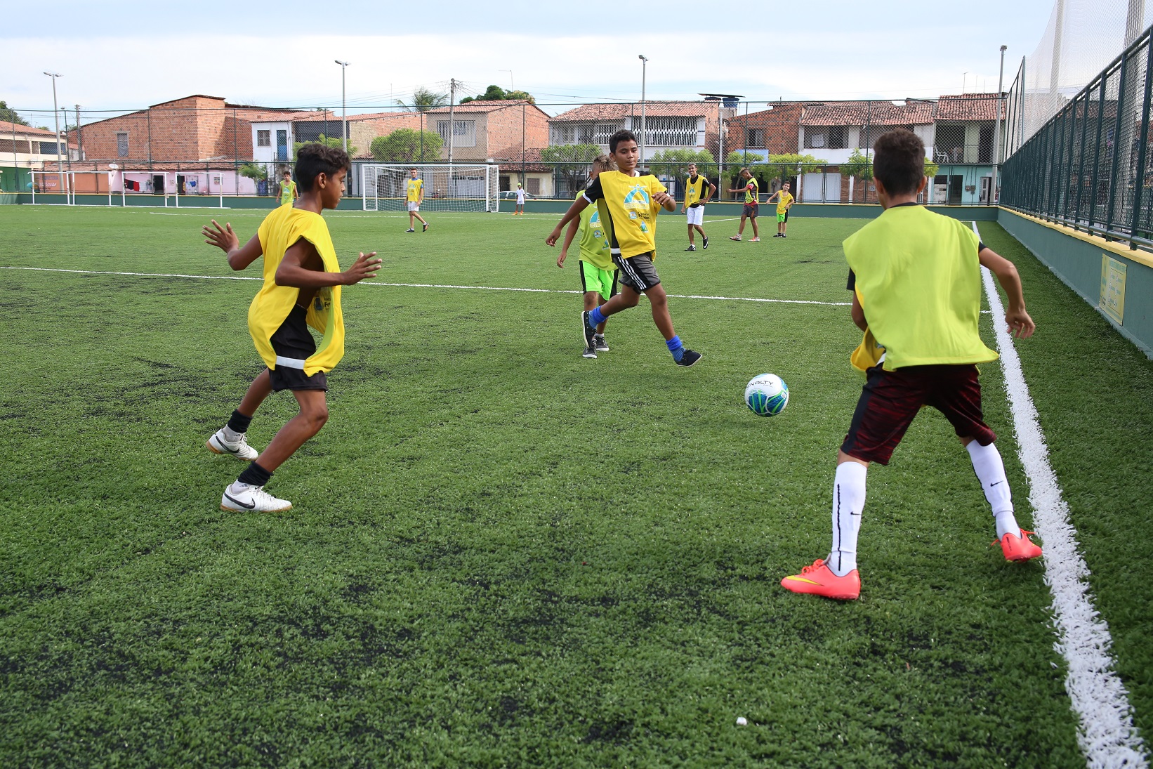 meninos jogando bola numa areninha